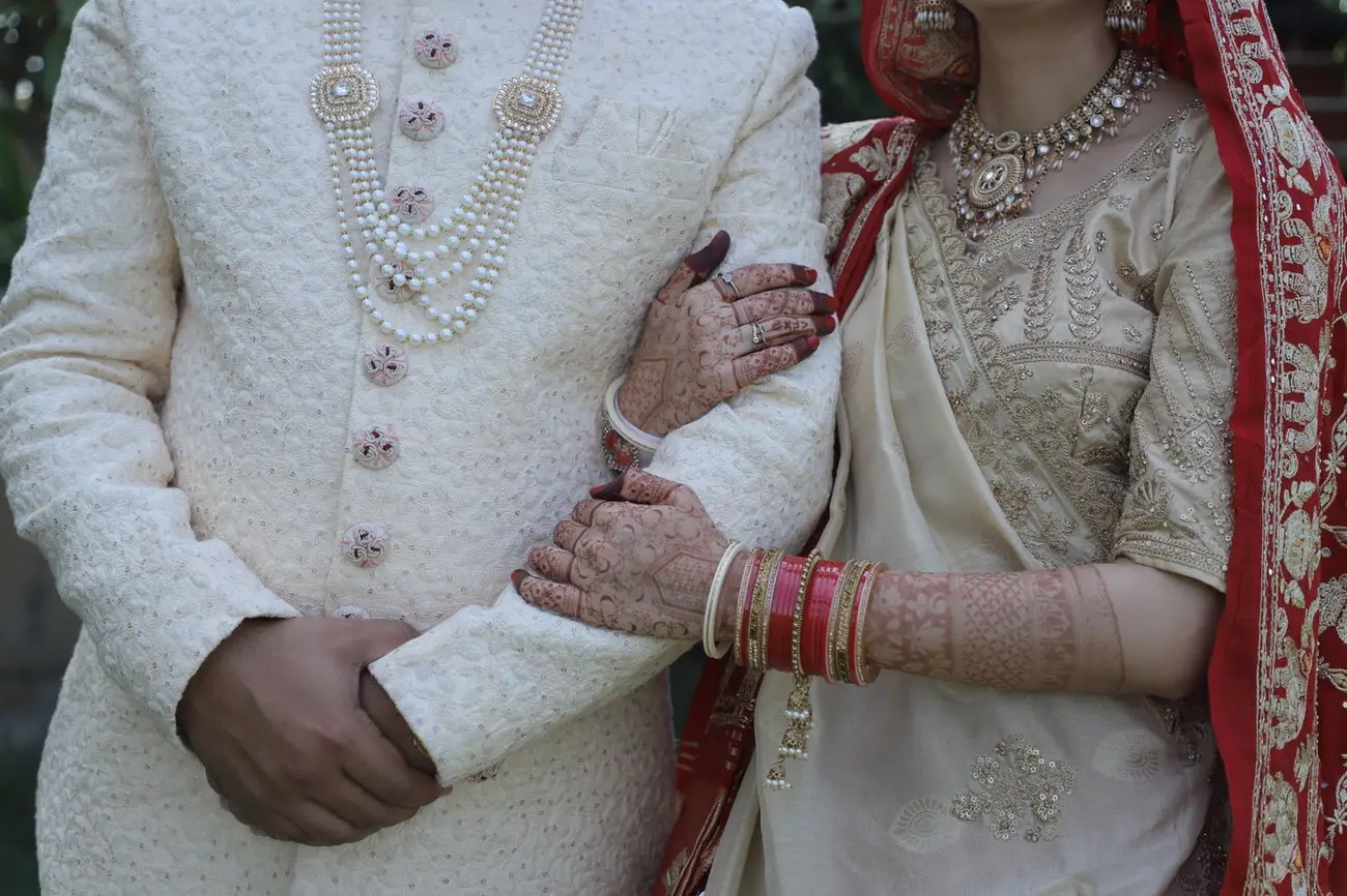 The groom in an ivory sherwani waiting before the baraat