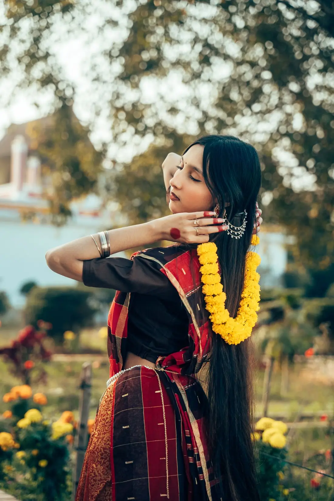 The bride in a marigold garland with her hair loose, photographed at golden hour