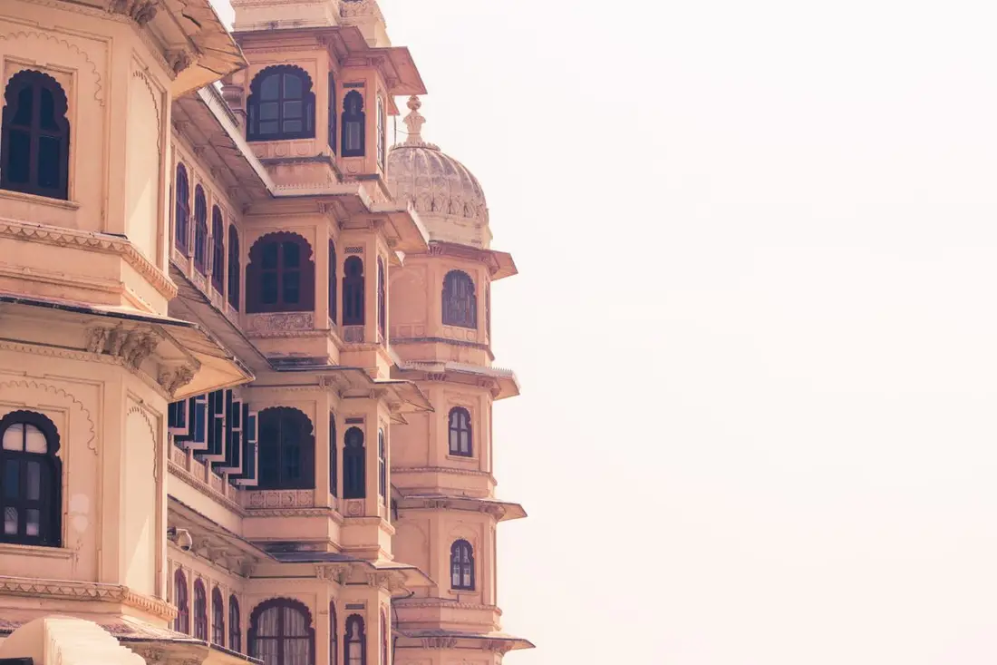 Carved sandstone domes and jharokhas of a Jaipur palace against the sky