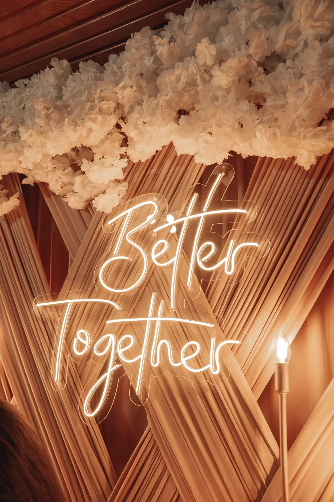A glowing Better Together sign against the reception decor