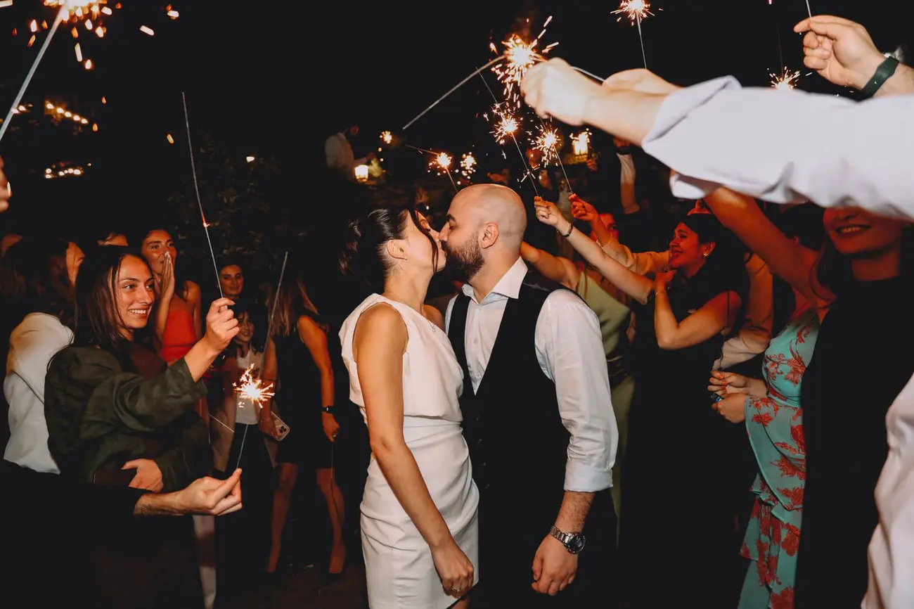The couple under warm string lights at their evening celebration